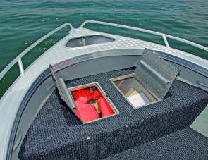 There's a wide storage compartment under the front deck. Note the tie down handles for the owner's crab pots. 